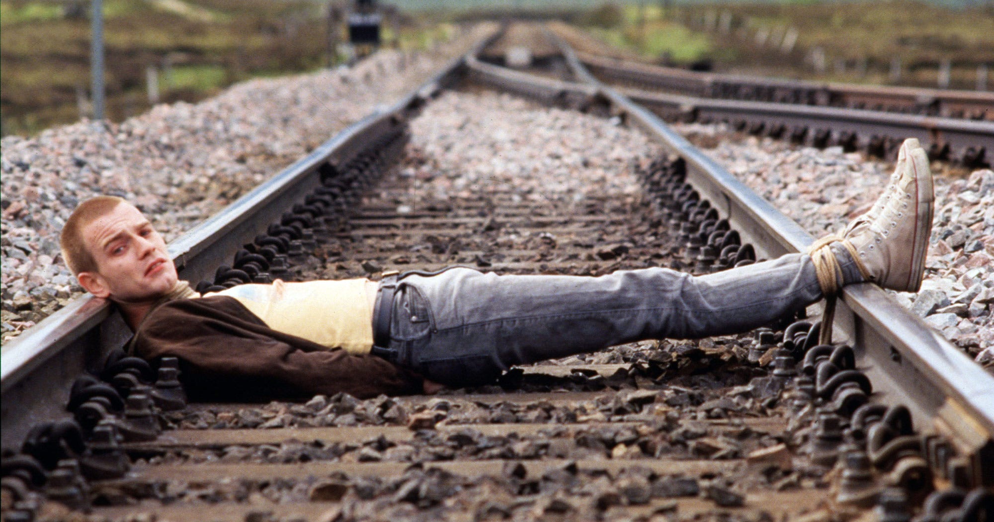 Ewan McGregor as Mark Renton laying on the train tracks in Trainspotting
